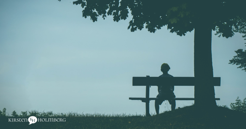 Photo of person sitting alone on a bench. Loneliness has spike during COVID.